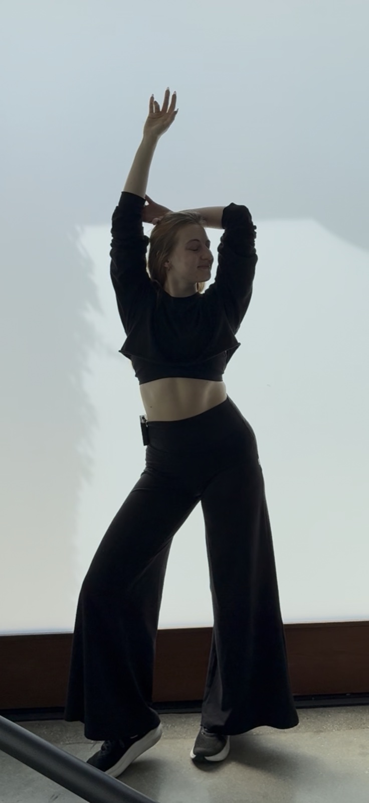 Jordie Morris stretching with one arm raised in the studio
